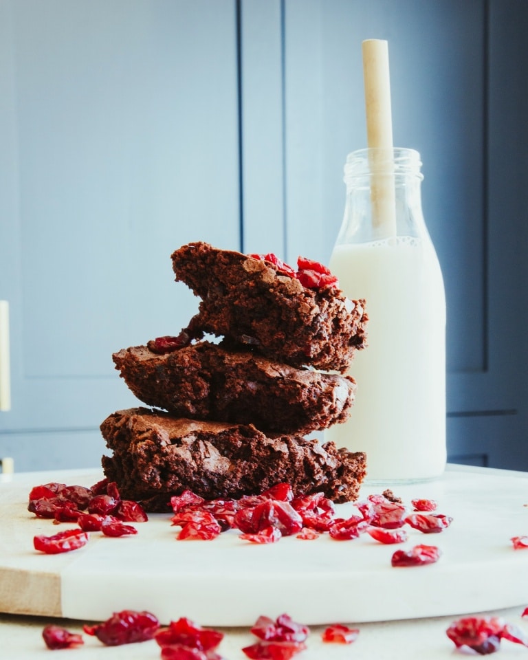 Stack of brownies with a glass of milk