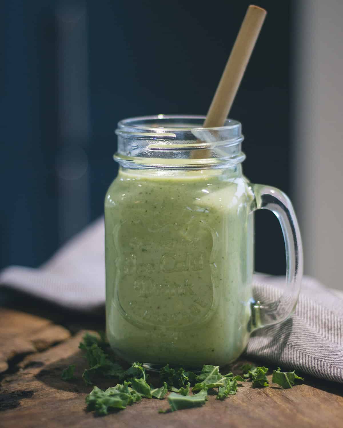 Green smoothie with a straw in a glass